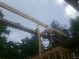 Carpenter setting a ridge beam over a new addition frame — Ice Dam Removal by Roofing Brothers in Santa Clara