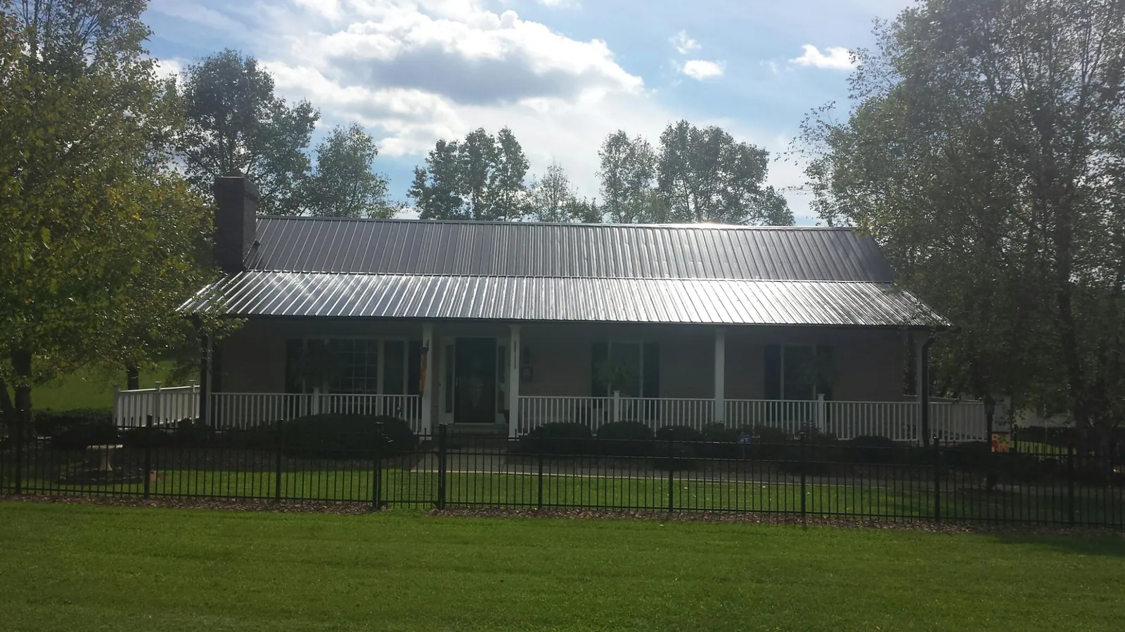 Gray metal roof on a brick ranch with a full width front porch — Gutter Guard Installation work by our crew in Santa Clara